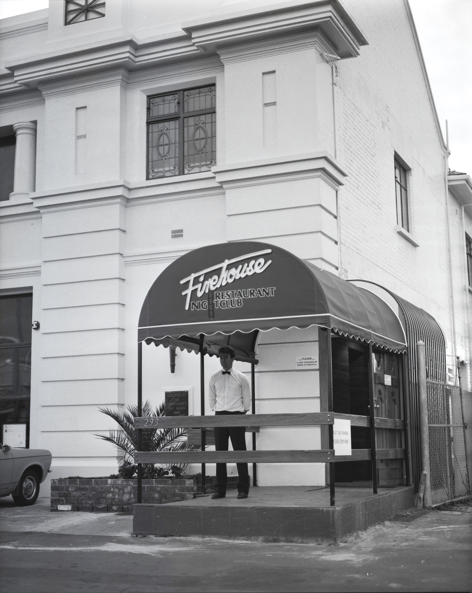 Firehouse Restaurant Nightclub entrance at 293 Colombo Street, Sydenham, Christchurch, showing the distinctive arched awning and a doorman in bow tie