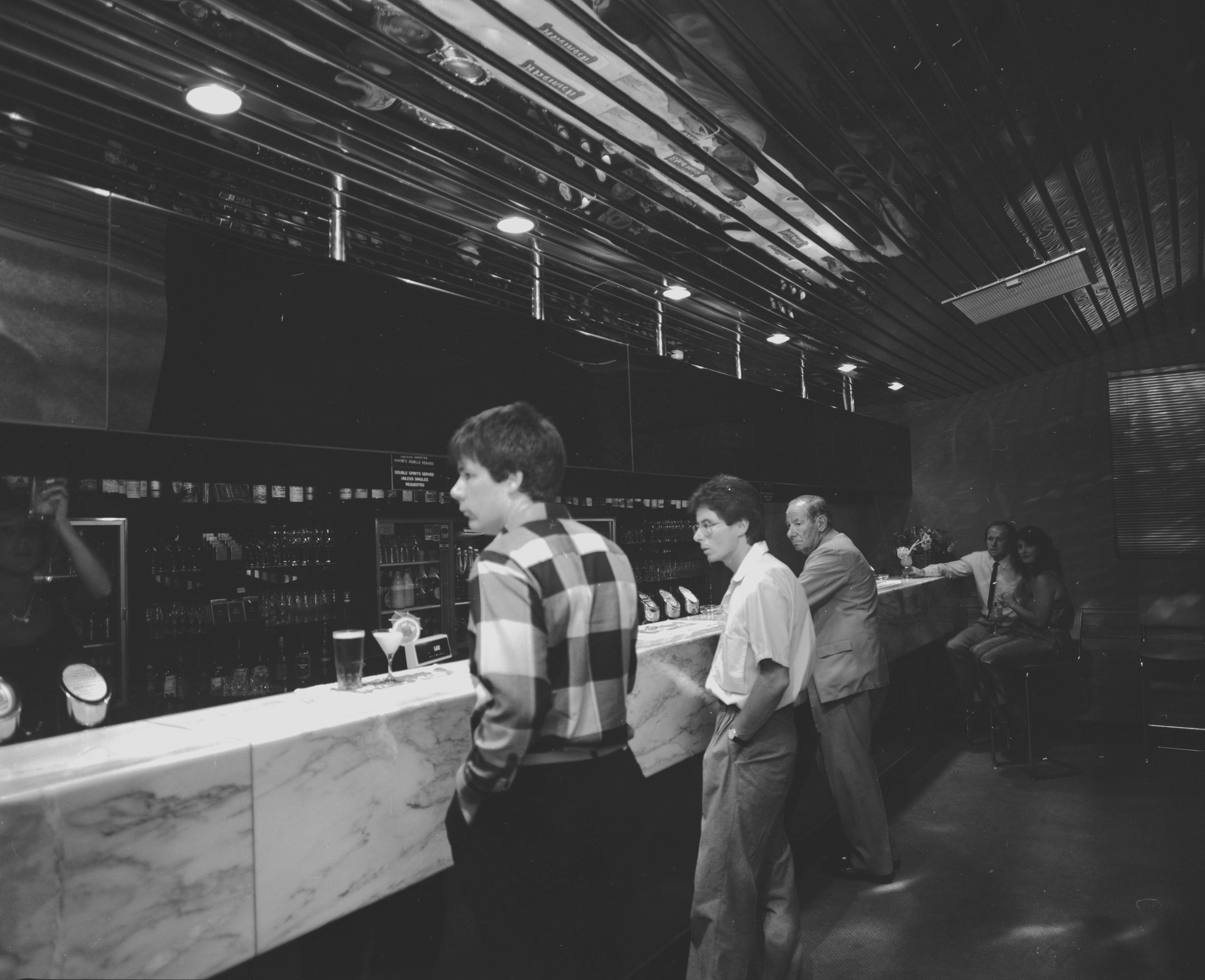 Interior of the Firehouse Nightclub, Christchurch, showing the split-level layout with curved booth seating, mezzanine level, and globe chandelier